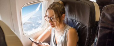 plan a vacation - woman using phone on plane