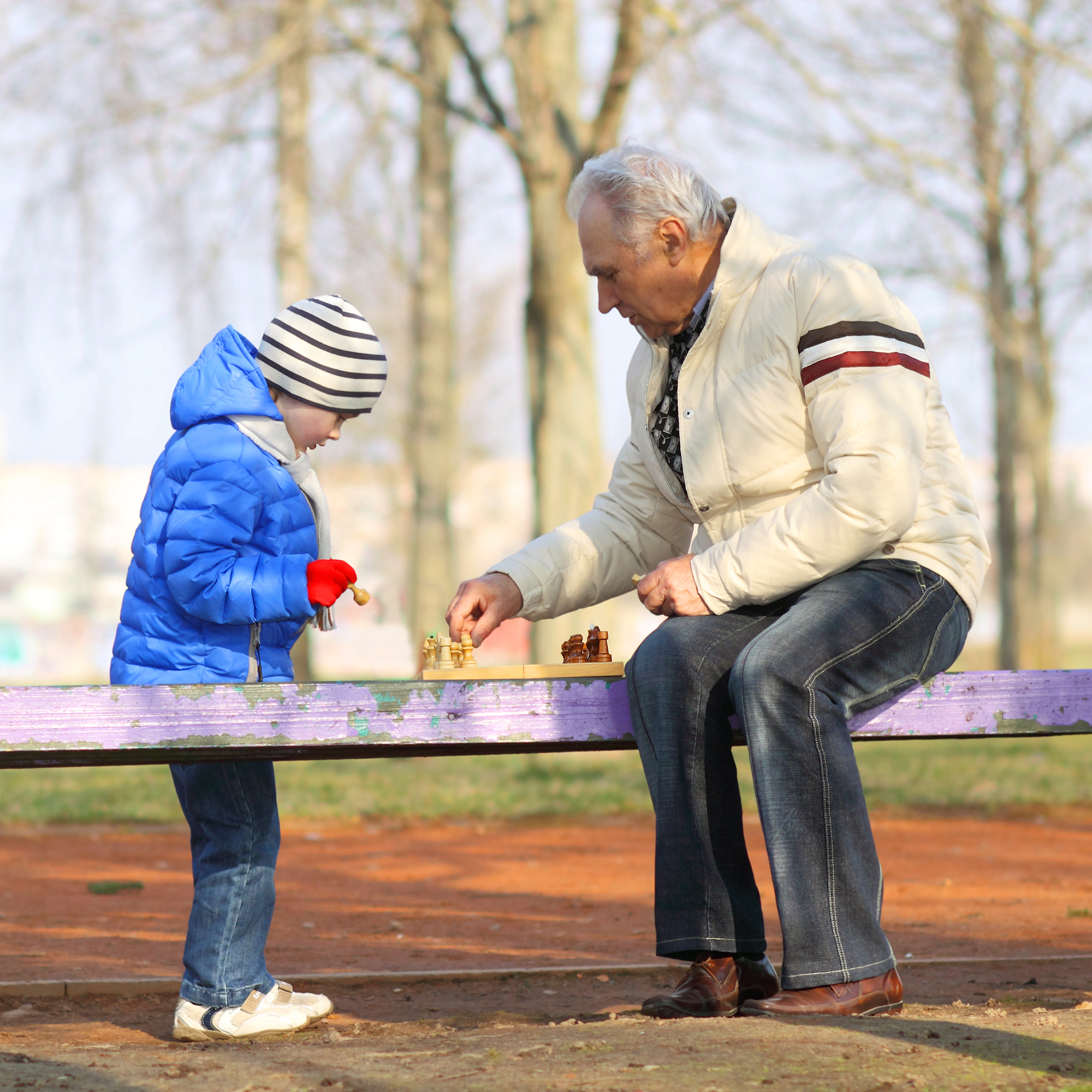 Дед с внуком играют в шашки. Дед и внук на скамейке. Дед на лавочке с внуком. Дедушка с внуками на скамейке. Дед с внуком в парке на лавочке.