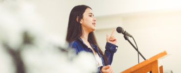 public speaking - woman speaking in microphone