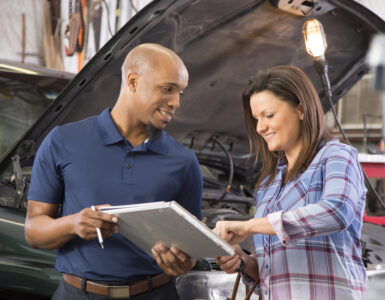 woman and mechanic at car shop