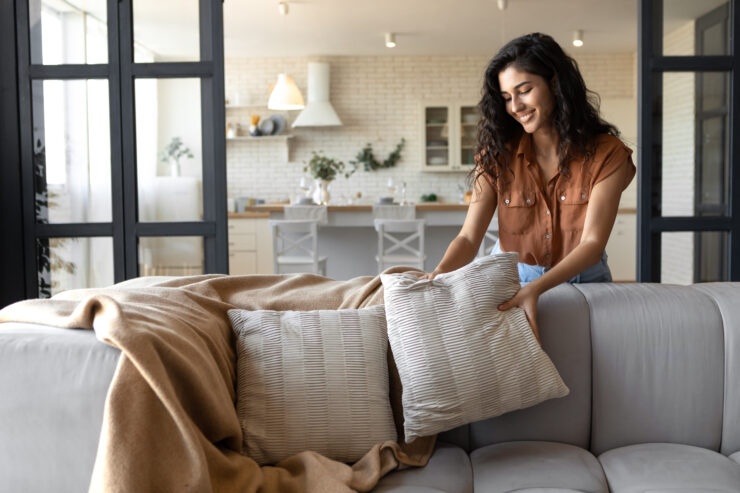 home finds - woman putting pillows on couch