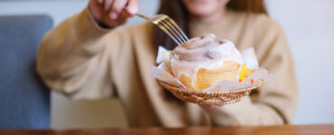 woman eating cinnamon bun