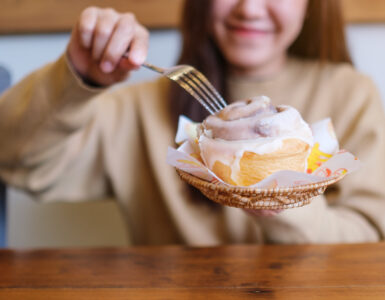 woman eating cinnamon bun