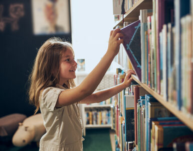 girl getting book off shelf