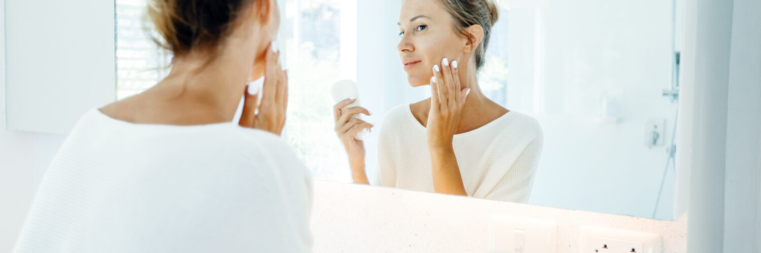daily sunscreen - woman looking in mirror