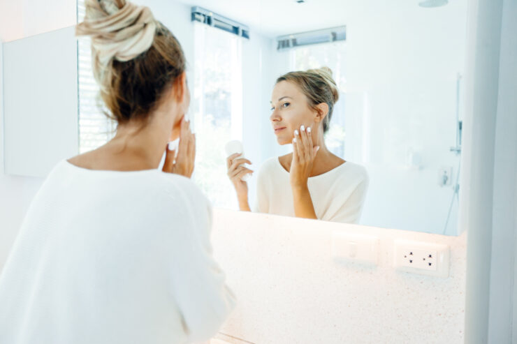daily sunscreen - woman looking in mirror
