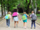 small schoolchildren with colorful school bags and backpacks run to school. Back to school, education, elementary school.