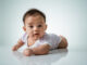 baby laying on her belly. tummy time cute baby in studio portrait on white background